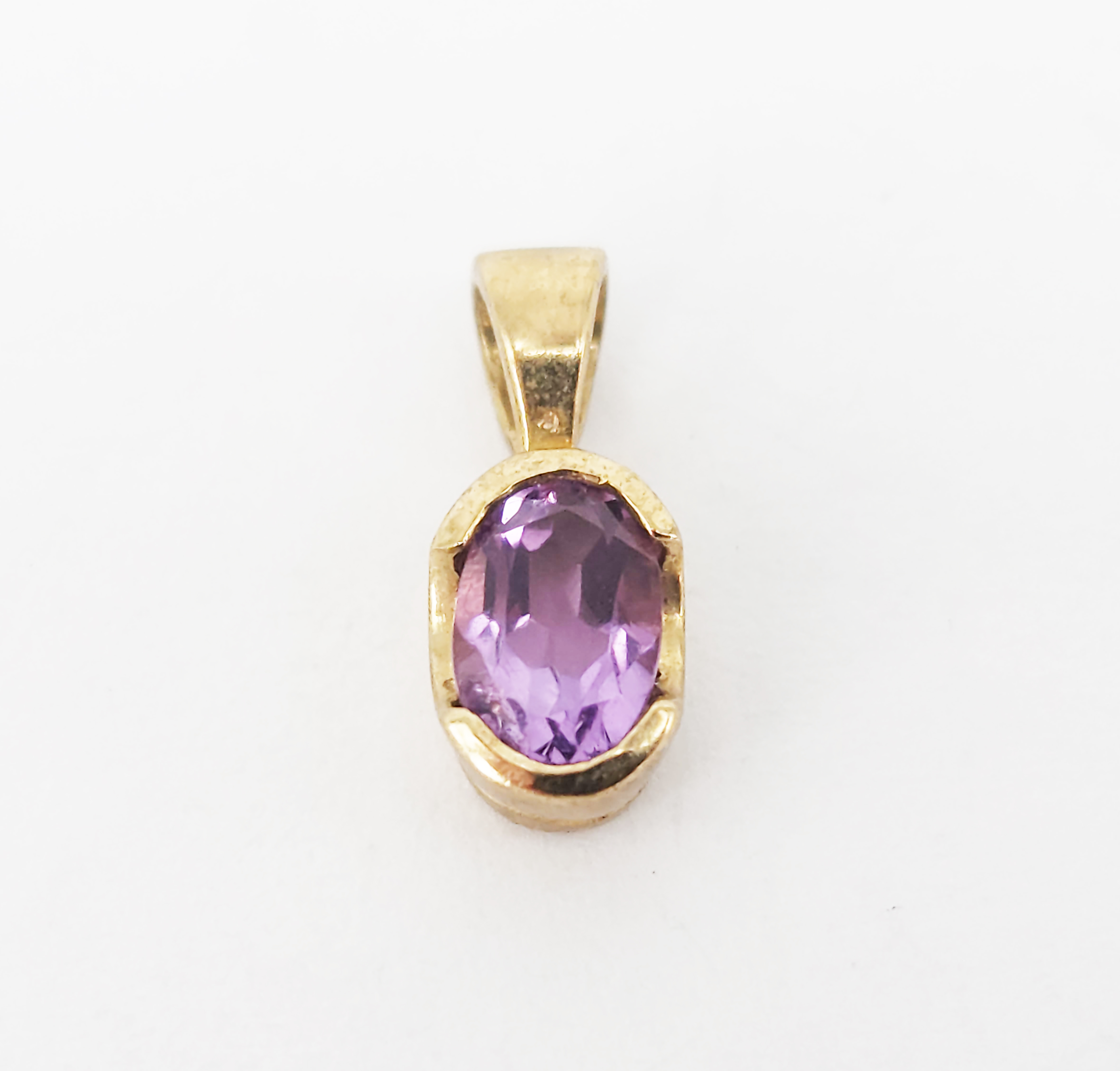 344 · A 9ct YELLOW GOLD AND AMETHYST PENDANT