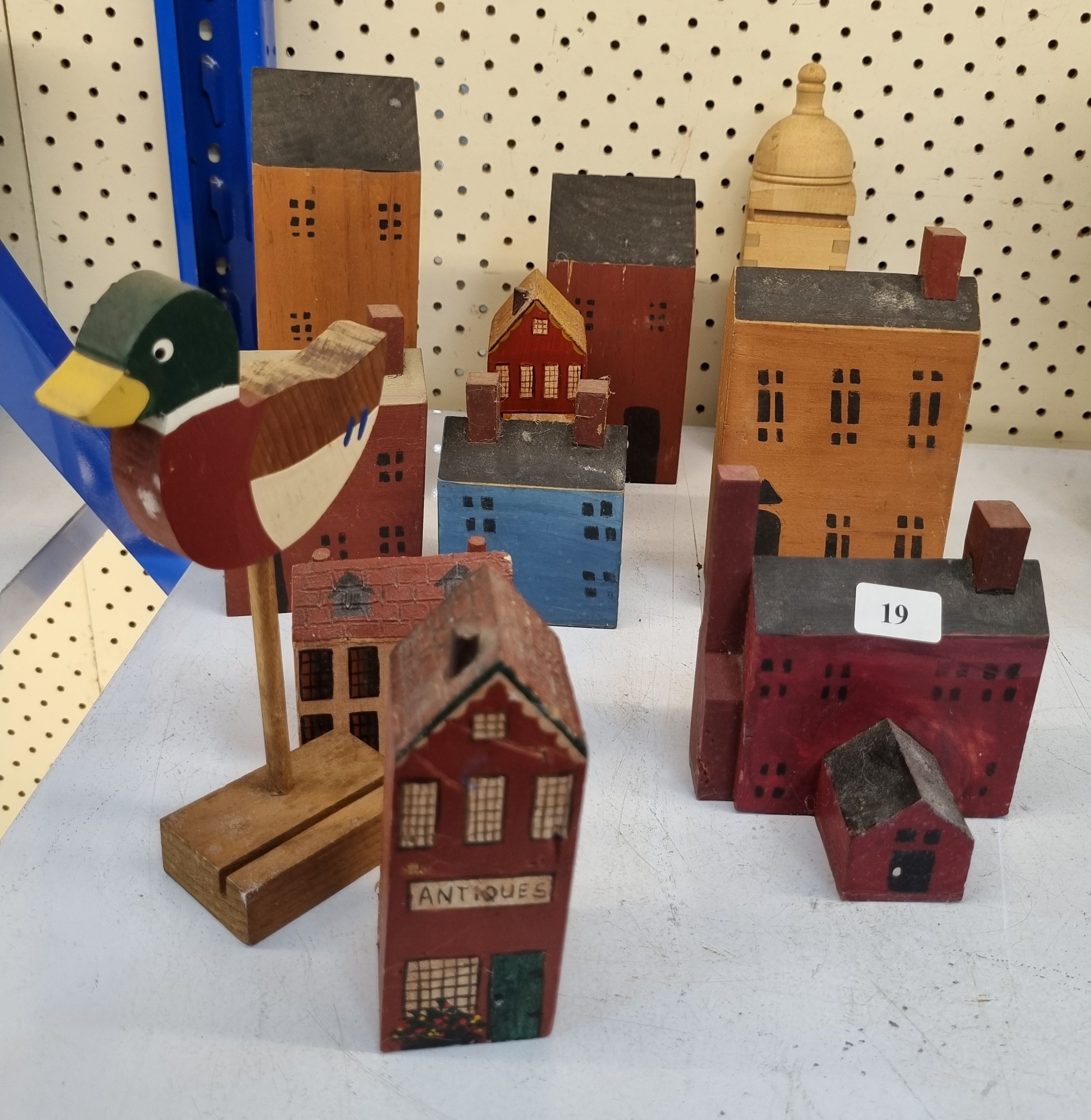 19 · A GROUP OF HANDPAINTED WOODEN BUILDINGS AND A DUCK