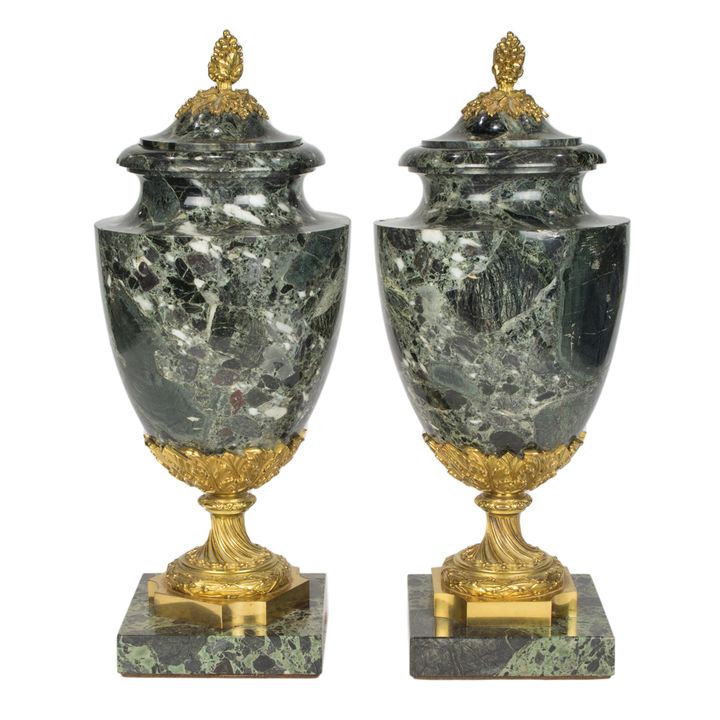 A pair of Louis XVI style gilt bronze mounted marble covered urns