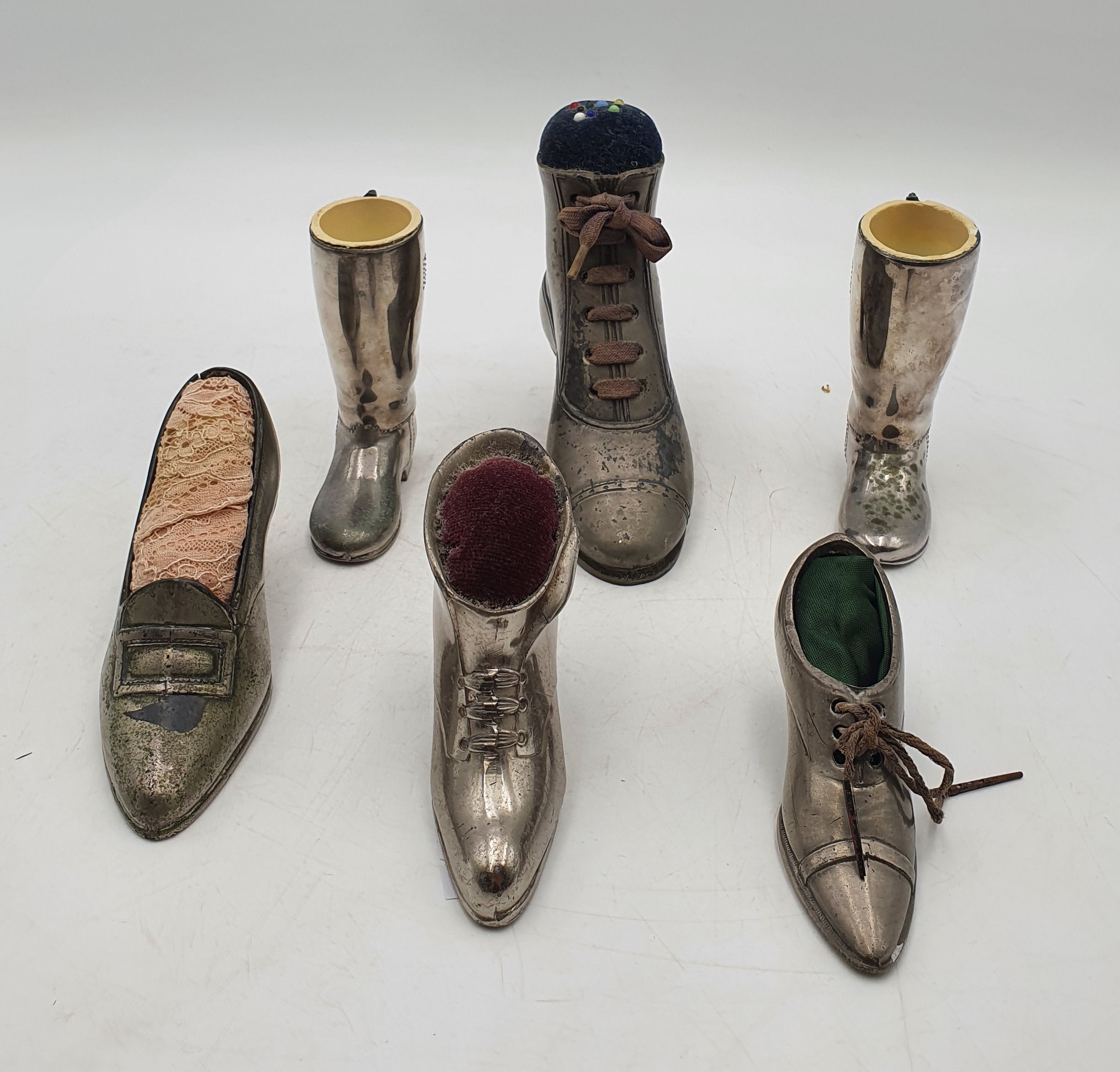 557 · FOUR VINTAGE SILVER PLATED SHOE FORM PIN CUSHIONS various sizes