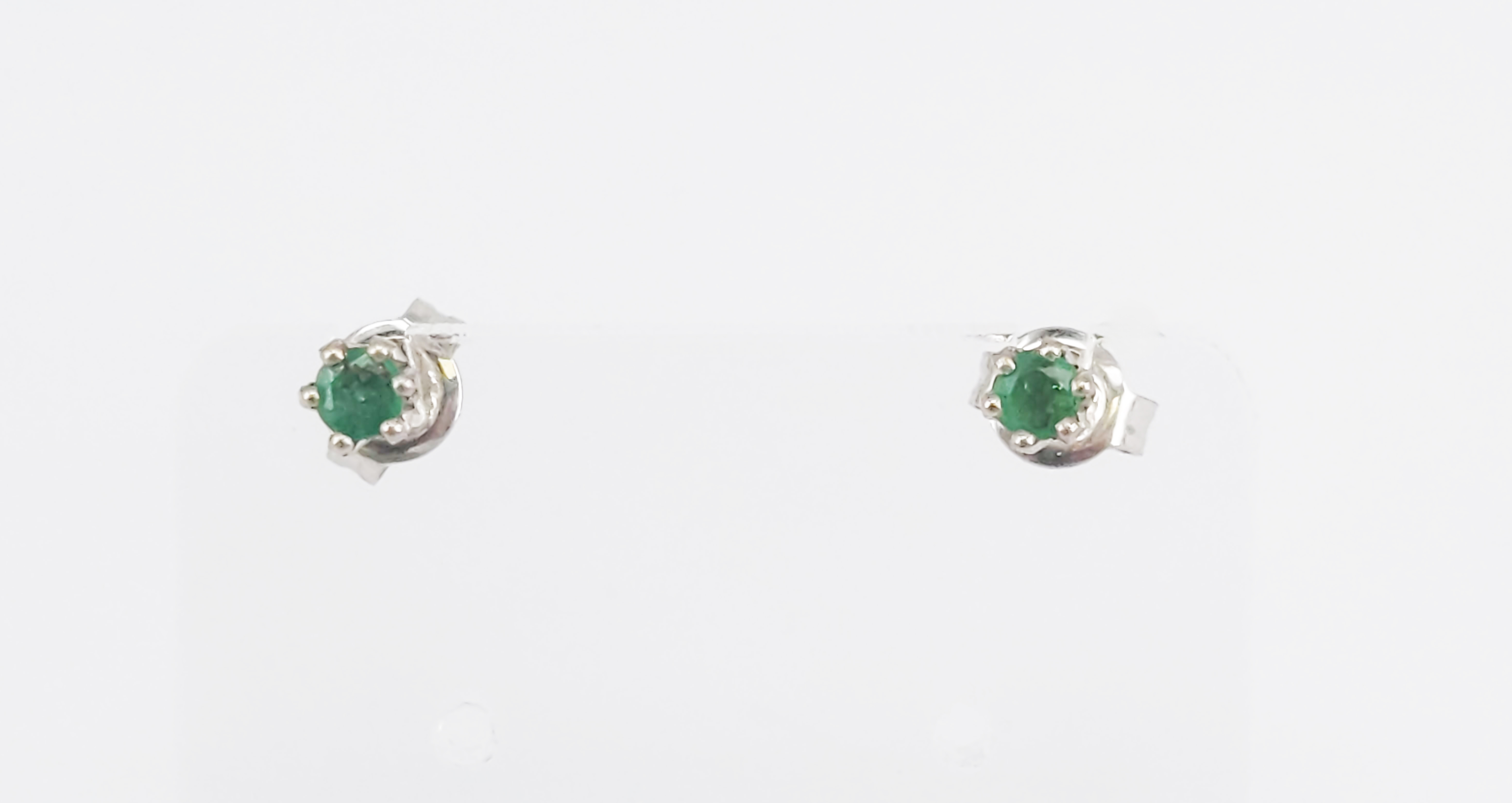 119 · A PAIR OF 9ct WHITE GOLD AND NATURAL EMERALD STUD EARRINGS