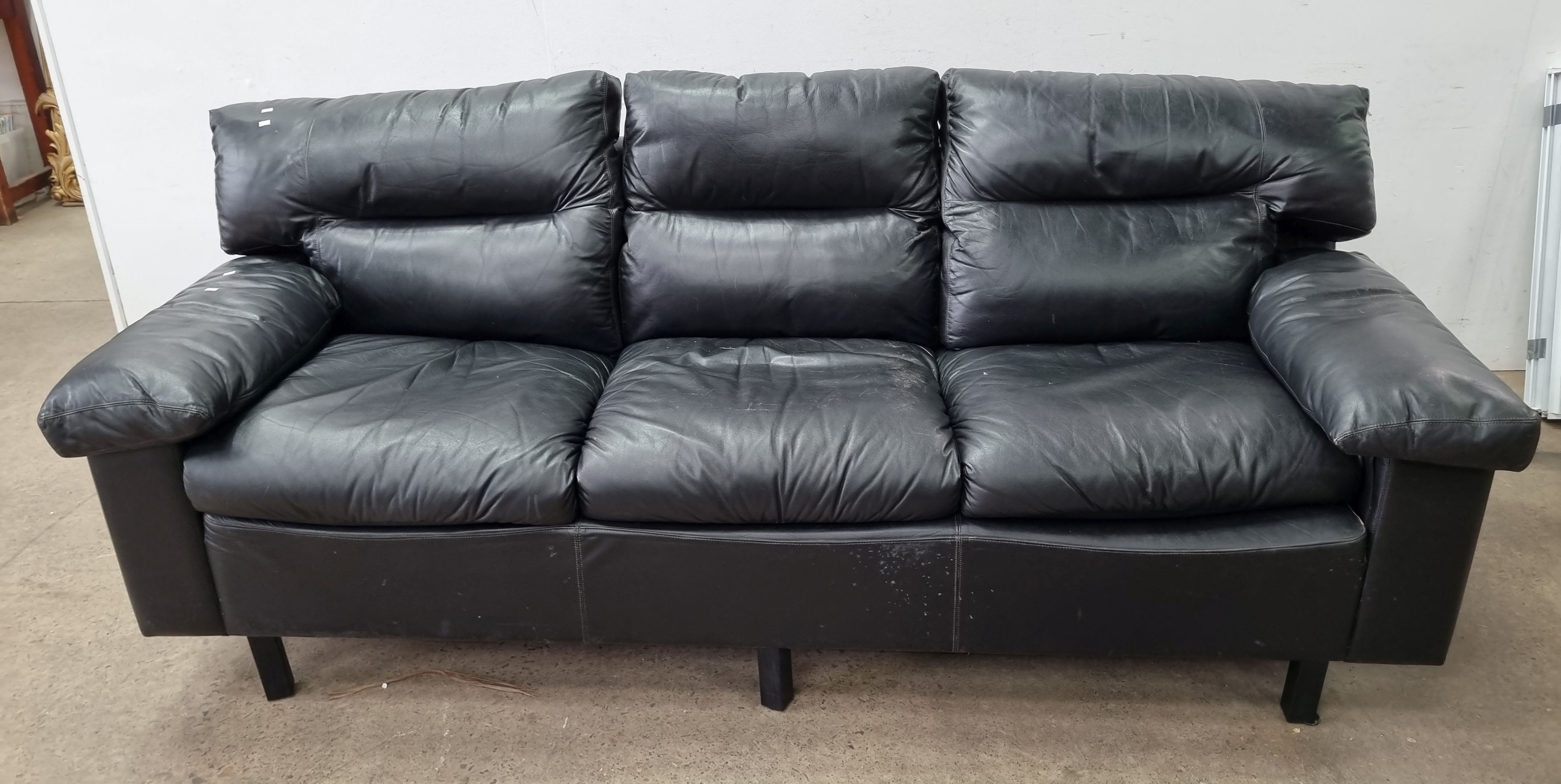 A McCANN & CO BLACK LEATHER THREE SEATER COUCH
