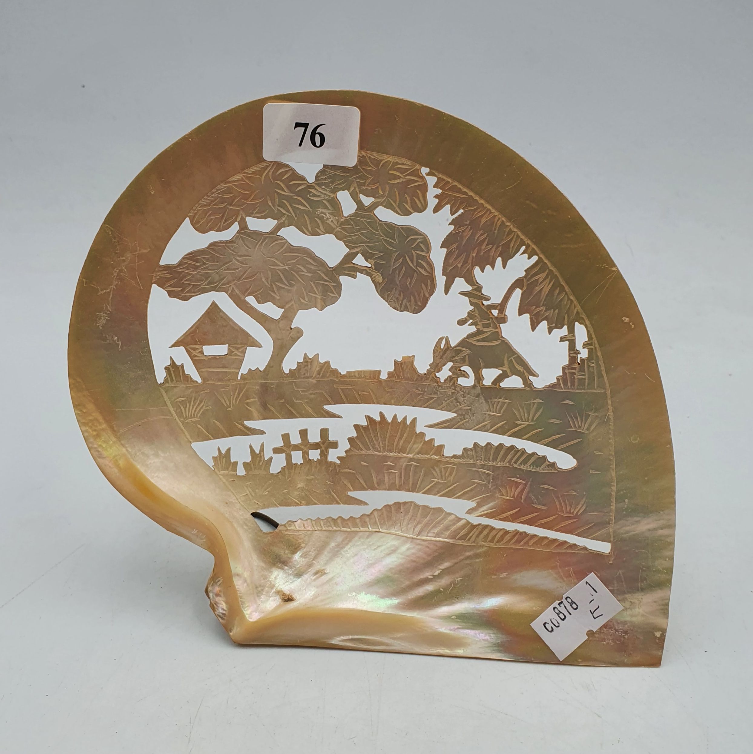76 · A MOTHER OF PEARL SHELL CARVED WITH A TROPICAL ASIAN THEME