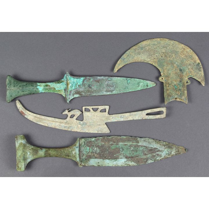 (lot of 4) Dongson bronze blades: consisting of an ax with scroll and sawtooth pattern; one blade with deer; together with two dagge...