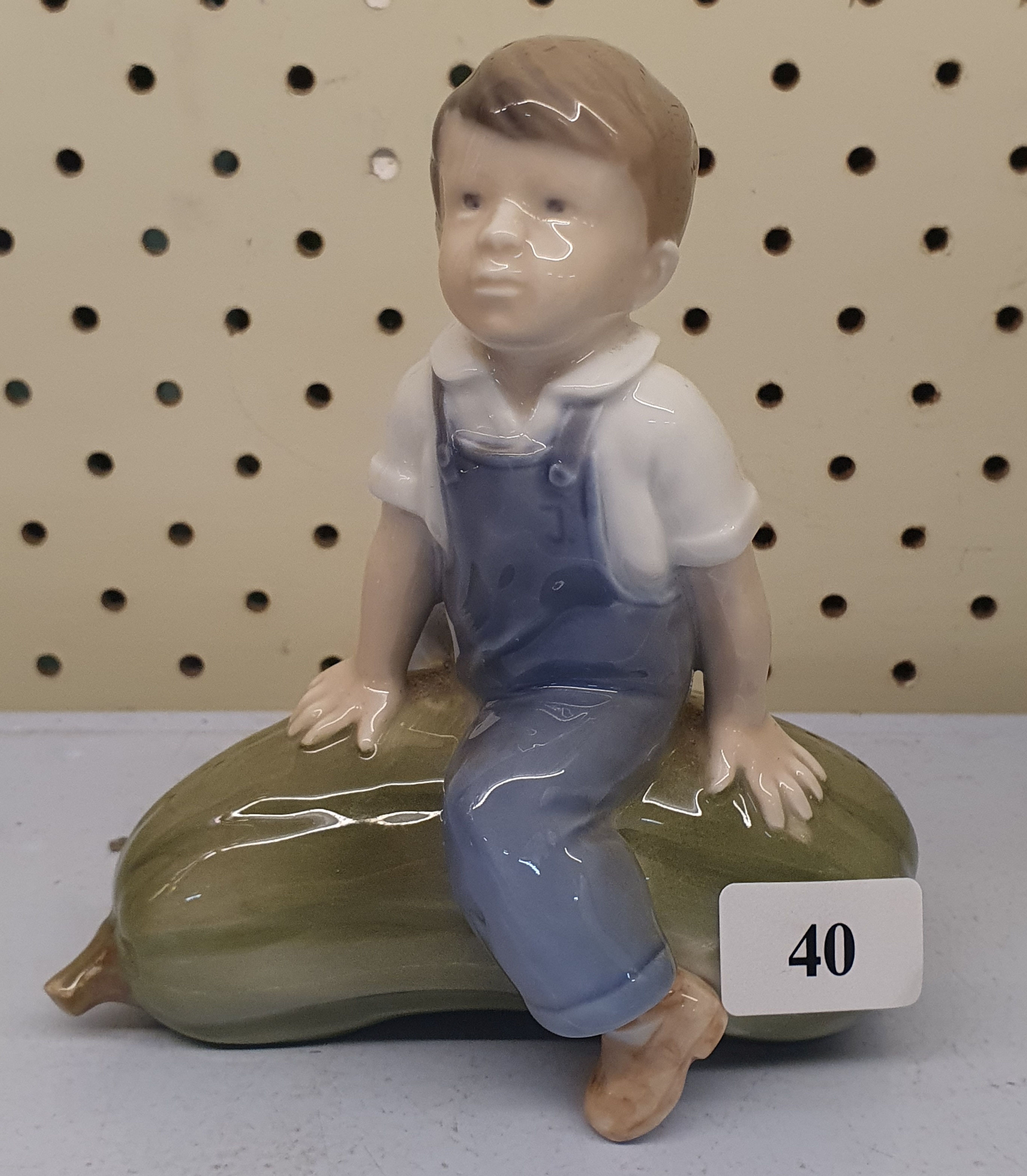 40 · A ROYAL COPENHAGEN PORCELAIN FIGURE OF A BOY ON A GOURD