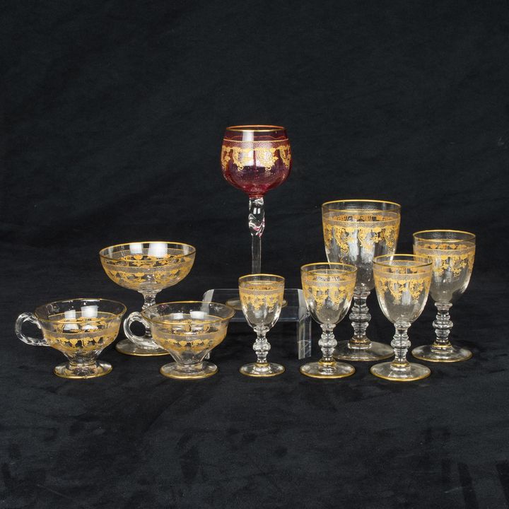 An assembled suite of gilt scroll decorated clear and cranberry glass stemware